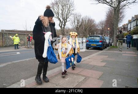 Brighton UK 8 mars 2021 - des enfants et des parents heureux arrivent à l'école primaire St Luke à Brighton ce matin, car les restrictions de verrouillage du gouvernement en Angleterre commencent à être assouplies . Les écoles et les collèges sont rouverts à tous les étudiants aujourd'hui dans toute l'Angleterre : crédit Simon Dack / Alamy Live News Banque D'Images