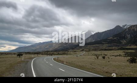 Route menant vers les montagnes, avec ciel nuageux. Photo en haute perspective réalisée dans le parc national d'Aoraki Mt Cook en Nouvelle-Zélande Banque D'Images