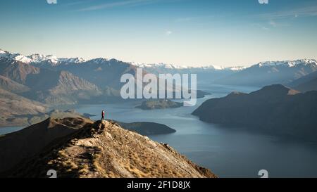 Les femmes se tenant sur le sommet de la montagne appréciant la vue sur le lac et les montagnes en début de matinée. Prise de vue au lever du soleil au sommet de Roys Peak Banque D'Images