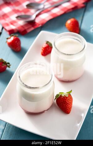 Panna cotta dessert avec fraise sur une table en bois bleu Banque D'Images