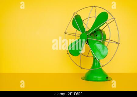 Ancien ventilateur électrique vert sur fond jaune Banque D'Images