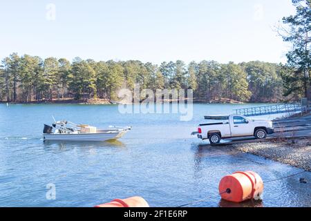 Pick-up tirer le bateau et la remorque hors de l'eau sur la rive d'un lac. Banque D'Images