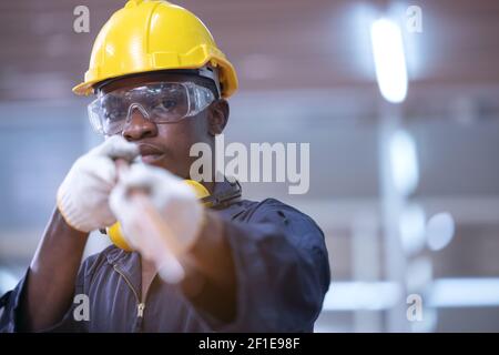 Casque jaune de travailleurs afro-américains noirs travaillant un fer dans l'usine industrielle. Banque D'Images