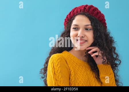 PORTRAIT D'UNE ADOLESCENTE EN VÊTEMENTS DE LAINE REGARDANT LOIN ET POSER Banque D'Images