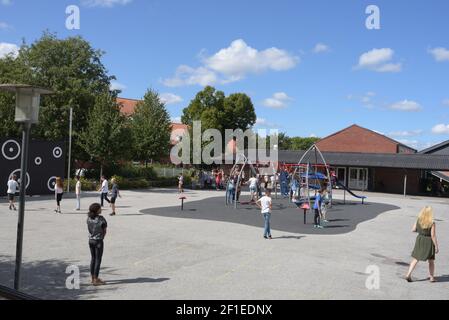 Un grand groupe d'enfants jouant sur l'aire de jeux pendant pause à l'école Banque D'Images