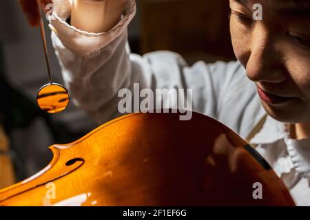 Jeune violoniste chinois au travail dans son atelier Banque D'Images