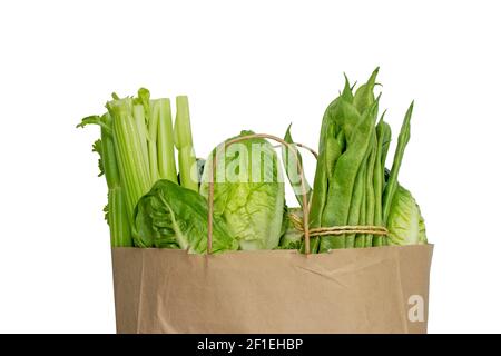 Légumes verts dans le sac de papier kraft brun de shopping isolé sur blanc Banque D'Images