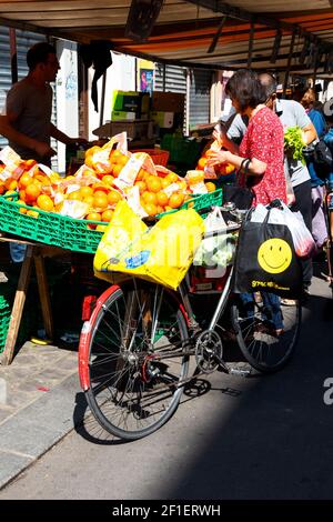 PARIS, FRANCE - 1er SEPTEMBRE 2018 : femme choisissant des oranges au marché de rue Beauvau. Banque D'Images