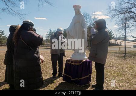 À la fin d'un service de plein air, les fidèles de l'Apostolat mondial de Saint Michel prient à une statue de la Vierge Marie. Dans un parc de Queens, N Banque D'Images