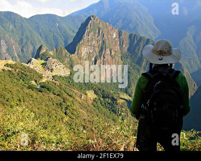 Trekker femelle surplombant Machu Picchu, la citadelle inca du XVe siècle située dans la Cordillère orientale au-dessus de la Vallée Sacrée, à Cusco Pérou. Banque D'Images