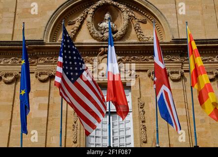 Les drapeaux de la France, des Etats-Unis, du Royaume-Uni, de l’Union européenne et de la Provence sont suspendus devant l’Hôtel de ville ou l’Hôtel de ville sur la place de l’Hôtel de ville. Il a été construit entre 1655 et 1678 à des dessins, influencé par des palazzos italiens, par l'architecte Pierre Pavillon, assisté des sculpteurs Jean-Claude Rambot et Jacques Fossé. La façade, décorée de guirlandes de fruits, de scrollwork baroque et d'un buste symbolisant la République française, a été une fois de plus ornée, mais la Révolution française et le passage du temps l'ont dépouillée de statues d'ange, de monogrammes royaux et de bustes des comtes de Provence. Banque D'Images