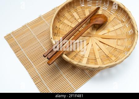 Couverts en bois, baguettes en bois, panier en bambou, tapis en bambou Banque D'Images