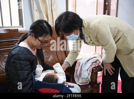 (210308) -- GUANGZHOU, le 8 mars 2021 (Xinhua) -- Guan Yanping (R) rend visite à la famille dans le village Sanban du district de Jinwan, dans la ville de Zhuhai, dans la province de Guangdong, au sud de la Chine, le 3 mars 2021. En 2017, Guan Yanping a quitté Zhuhai de la province de Guangdong dans le sud de la Chine pour travailler comme médecin aidant à Nujiang, dans la province du Yunnan dans le sud-ouest de la Chine. Au cours des dernières années, elle a fait plus de 500 randonnées sur les sentiers escarpés et étroits de la montagne pour traiter les villageois locaux. Le 8 mars marque la Journée internationale de la femme, qui est une journée mondiale célébrant les réalisations sociales, économiques, culturelles et politiques de Wom Banque D'Images