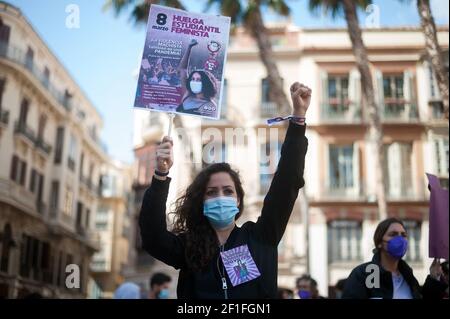 Malaga, Espagne. 08 mars 2021. Une femme portant un masque facial est vue monter sa poing et tenir une affiche lors d'une manifestation féministe par des associations d'étudiants à la Plaza de la Constitución.les principales organisations de femmes ont organisé plusieurs manifestations et initiatives en Espagne pour commémorer la Journée internationale de la femme, Suite à la décision du gouvernement espagnol d'interdire toute manifestation massive à Madrid ou à ceux de plus de 500 personnes, par mesure de précaution contre la pandémie du coronavirus. Crédit : SOPA Images Limited/Alamy Live News Banque D'Images