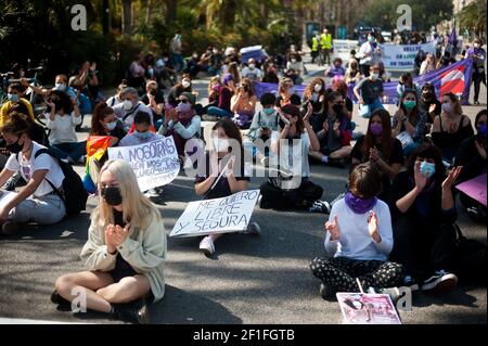 Malaga, Espagne. 08 mars 2021. Des manifestants sont vus assis dans la rue et tenant des pancartes lors d'une manifestation féministe par des associations d'étudiants sur la Plaza de la Constitución.les principales organisations de femmes ont organisé plusieurs manifestations et initiatives en Espagne pour commémorer la Journée internationale de la femme, Suite à la décision du gouvernement espagnol d'interdire toute manifestation massive à Madrid ou à ceux de plus de 500 personnes, par mesure de précaution contre la pandémie du coronavirus. Crédit : SOPA Images Limited/Alamy Live News Banque D'Images
