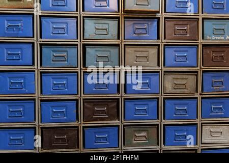 Un mur avec de nombreux tiroirs en métal bleu et brun vintage brillant. Photo prise sur un marché aux puces près de Treptower Park. Concept : stockage, base de données, documents, Banque D'Images