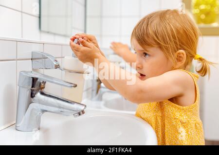 Enfant de la maternelle à laver ses mains Banque D'Images