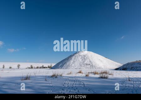 La neige couvrait l'ancien paysage du Wiltshire à Silbury Hill, une partie du site du patrimoine mondial d'Avebury. Banque D'Images