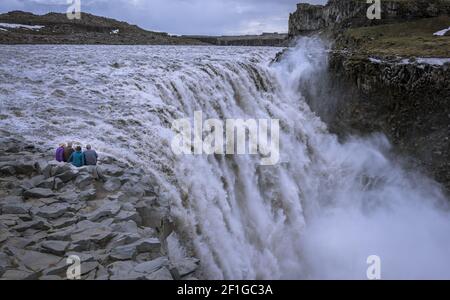 Les voyageurs âgés contemplant la chute d'eau de la Detifoss au bord de l'Islande. Banque D'Images