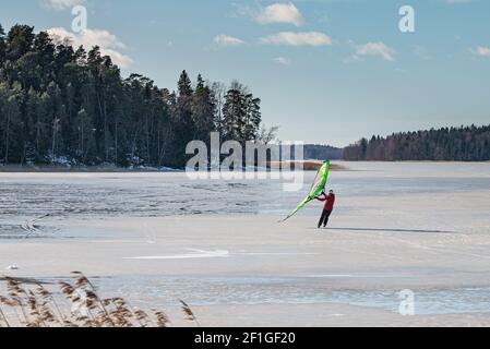 Homme sur des patins à glace propulsés par une voile de surf. Sports d'hiver, loisirs actifs, passe-temps Banque D'Images