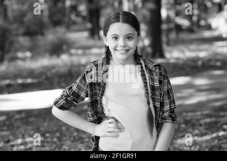 Fille scout mignon braides porter des vêtements à carreaux nature fond, concept de camp d'été. Banque D'Images