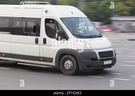 Minibus blanc va sur la ville street Banque D'Images