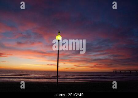 Crépuscule juste avant le lever du soleil sur l'horizon de l'océan Pacifique, Seagul au lampadaire, aube civile à New Brighton Beach, Christchurch en Nouvelle-Zélande Banque D'Images