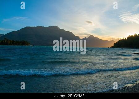 Wilson Bay près de Queenstown, Île du Sud de la Nouvelle-Zélande, la vue sur le lac Wakatipu, Cecil et Walter Peak, le soleil doré l'après-midi Banque D'Images