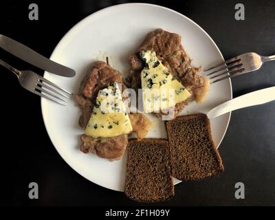 Une assiette à dîner pour deux avec des tranches de viande rôties avec fromage et pains de pain Banque D'Images