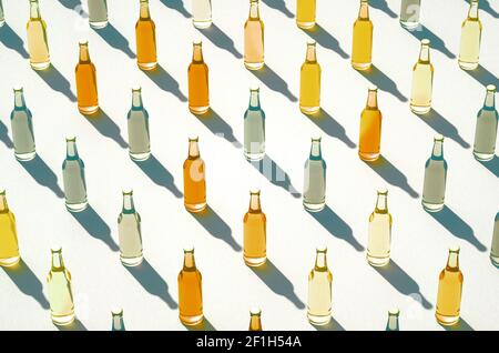 Vue aérienne sur les lignes de bouteille en verre maquettes 3d debout sur fond blanc. Bouteilles de soda de différentes couleurs avec de longues ombres alignées sur les rangées. Chambre rétro Banque D'Images