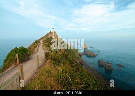 Phare de Nugget point et célèbres îlots rocheux (les Nuggets) sur la côte de l'océan Pacifique, randonnée de Tokata, sud de la Nouvelle-Zélande Banque D'Images