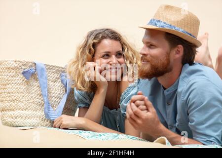 couple allongé sur une plage de sable blanc Banque D'Images