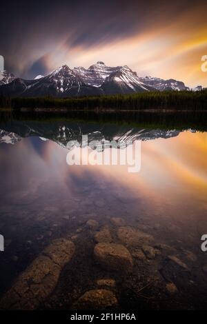 Les couleurs intenses du coucher du soleil se reflètent dans le lac Herbert le long de la promenade Icefields du parc national Banff. Banque D'Images