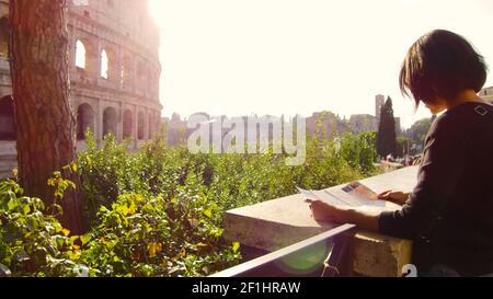 Femme regarde la carte touristique devant le majestueux Colisée à Rome Banque D'Images