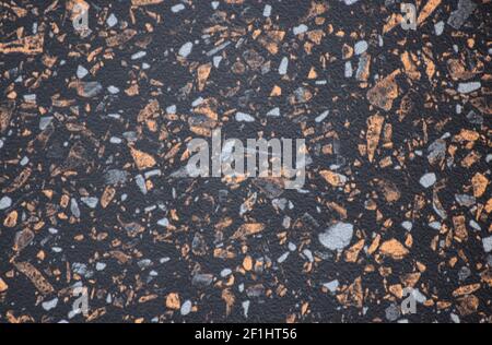 Granit noir, surface polie de pierre naturelle avec petites inclusions orange et blanche. Arrière-plan, motif, texture. Banque D'Images