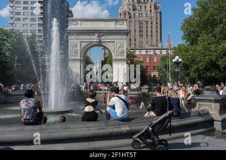 États-Unis, New York City, NY - les gens se frayent dans la fontaine de Washington Square dans le parc Washington Sqaure, en face de Washington Square Arch Banque D'Images