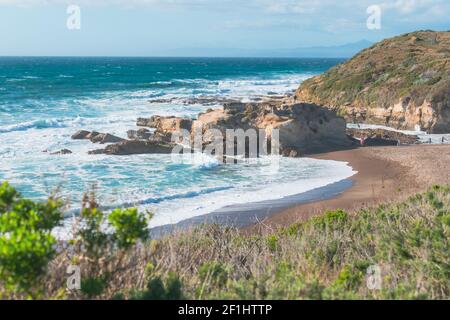 Montana de Oro, Californie, États-Unis - 6 mars 2021. Falaises rocheuses, plage de sable, et les gens appréciant une belle journée ensoleillée. Parc national du Montana de Oro, Los O Banque D'Images