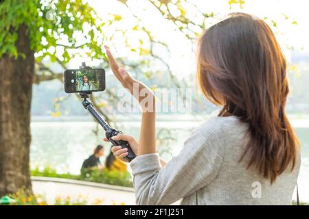 Femme asiatique enregistrant des vidéos dans la rue à Hanoi, Vietnam Banque D'Images