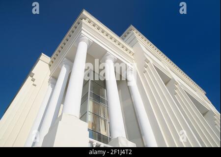 Façade blanche de style classique avec montants contre ciel bleu clair. Architecture moderne. Vue à angle bas Banque D'Images