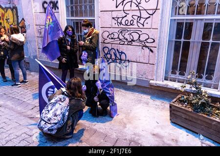 Istanbul, Turquie. 08 mars 2021. Les manifestants qui détiennent des drapeaux féministes se reposent sur la marche.plusieurs personnes se sont rassemblées à Taksim avec l'intention de faire une parade de nuit en l'honneur de la Journée internationale de la femme, le 8 mars cependant en raison de la restriction de rassemblement du gouverneur d'Istanbul, la police locale a empêché le groupe d'effectuer le défilé. En réponse à cela, le groupe est passé de Taksim à Karaköy tout en démontrant leurs opinions féministes. Crédit : SOPA Images Limited/Alamy Live News Banque D'Images