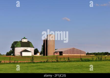 Kaneville, Illinois, États-Unis. Une grange ronde distinctive se trouve le long de silos latéraux et de bâtiments variés sur une ferme dans le nord-est de l'Illinois. Banque D'Images