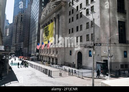 State Street Global Advisors fête son entrée à la bourse de New York et à la Journée internationale de la femme avec l'installation de verre brisé autour de la sculpture Fearless Girl, en face de la Bourse de Broad Street à New York, le 8 mars 2021. Le message avec cette installation a déclaré "les plafonds de verre cassés d'aujourd'hui sont les pierres de marche de demain". L'installation représente une fille sans fiard qui se lève du verre brisé qui se pose autour. Des enseignants de l'école voisine ont amené des élèves de 2e année à leur enseigner la Journée internationale de la femme et l'importance d'être intrépide et d'essayer d'atteindre des objectifs apparemment impossibles. (Photo par Banque D'Images