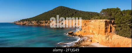 'Es bol Nou' est l'une des plages naturelles de l'île d'Ibiza. Entouré de falaises de calcaire qui lui donnent une couleur orange. C'est une plage typique Banque D'Images