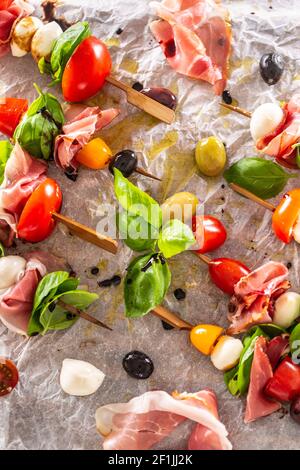 Brochettes de Caprese tomates italiennes ou méditerranéennes mozzarella olives et prosciutto Banque D'Images