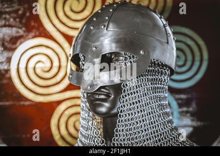 Casque viking avec mail chaîne de fer sur bouclier rouge de bois et golden triskel Banque D'Images