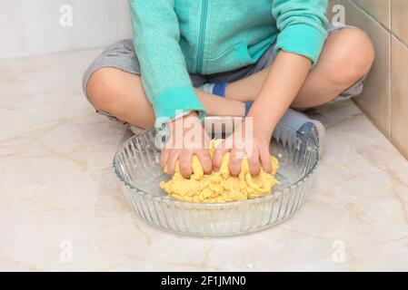 Mains d'un enfant pétriant de la pâte pour pizza Banque D'Images