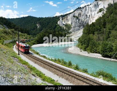 Le train Rhaetian sur les rives du Rhin Rivière dans la gorge de Ruinaulta Banque D'Images