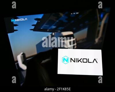 Personne tenant un smartphone avec le logo de la société américaine de véhicules électriques Nikola Corporation à l'écran devant le site Web. Mise au point sur l'affichage du téléphone. Banque D'Images