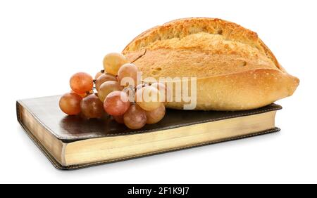 Sainte Bible avec du pain et des raisins sur fond blanc Banque D'Images