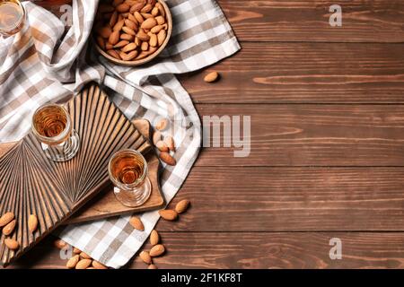 Composition avec verres de liqueur d'amande et noix sur bois arrière-plan Banque D'Images